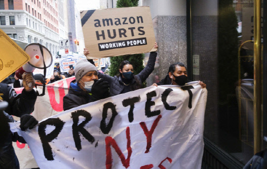 지난해 12월 아마존 전현직 근로자들이 아마존 CEO 제프 베이조스 소유 건물 앞에서 근로조건 개선을 요구하며 시위하고 있다.    [EPA 연합뉴스]